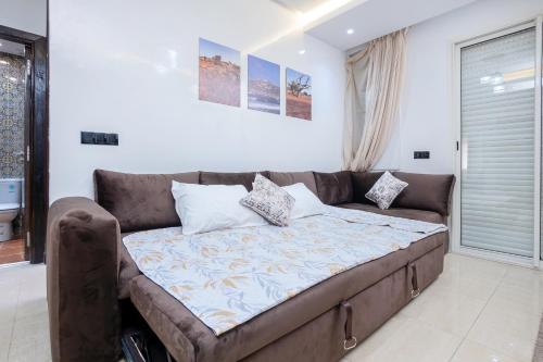 a large couch in a living room at Bel appartement piscine, 10 min stadium, souk, plage, bein sports in Agadir