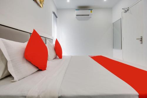 a bedroom with red and white pillows on a bed at Hotel O Sky White House in Ludhiana