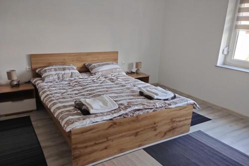 a bedroom with a large bed with two towels on it at Apartments with parking space Otok, Slavonija - 24625 in Otok