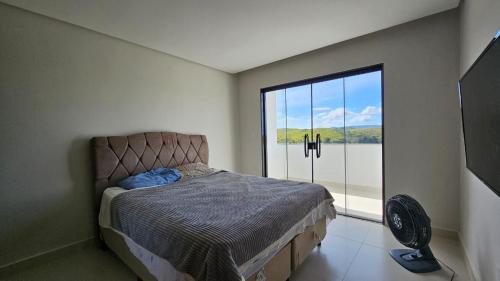 皮拉伊河畔巴拉Casa em Ipiabas的一间卧室，里面有一张床和一扇大窗户。