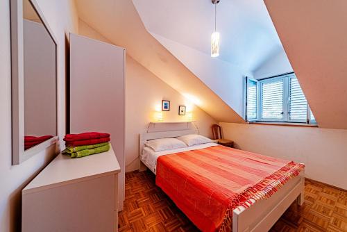 a small attic bedroom with a bed and a window at Apartments by the sea Brna, Korcula - 20827 in Smokvica