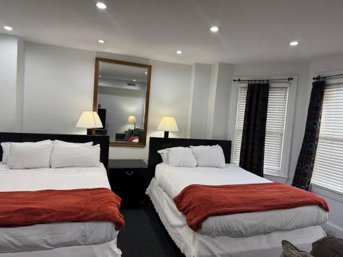 a bedroom with two beds and a mirror at Gorgeous Refurbished 1Bdrm and 1Den Home in Washington, D.C.