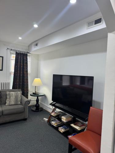 a living room with a large flat screen tv at Gorgeous Refurbished 1Bdrm and 1Den Home in Washington, D.C.