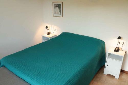 sypialnia z zielonym łóżkiem i 2 stolikami nocnymi w obiekcie Studio in Lazise/Gardasee 21938 w mieście Lazise