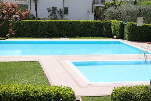 duży basen w ogrodzie z krzakami w obiekcie Studio in Lazise/Gardasee 21938 w mieście Lazise