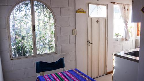 a kitchen with a counter and a window and a chair at Casita Meraki Duplex para 3 personas in Villa Carlos Paz