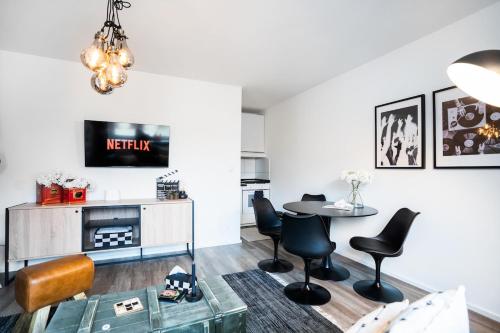 a living room with a table and chairs at 1 BR Studio - ZENTRAL - PARKHAUS - BUSINESS - KAFFEE - NETFLIX - SMART TV - KÜCHE in Wiesbaden