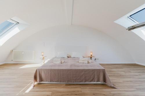 a white bedroom with a bed in a room with windows at 2 BR Penthouse Loft - WHIRLPOOL - TERRASSE - WIFI - ZENTRAL - KÜCHE - KAFFEE - PARKHAUS in Wiesbaden
