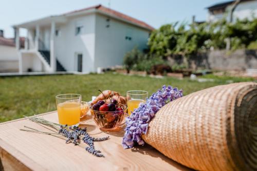 a table with a basket of fruit and glasses of orange juice at Casa da Teresa in Luso