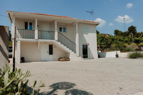 a white house with a balcony and a driveway at Casa da Teresa in Luso