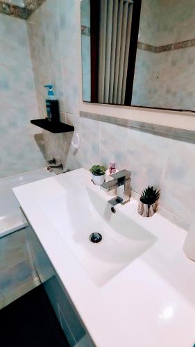 a white sink in a bathroom with a mirror at Helen's Cosy House In Miller in Mount Pritchard