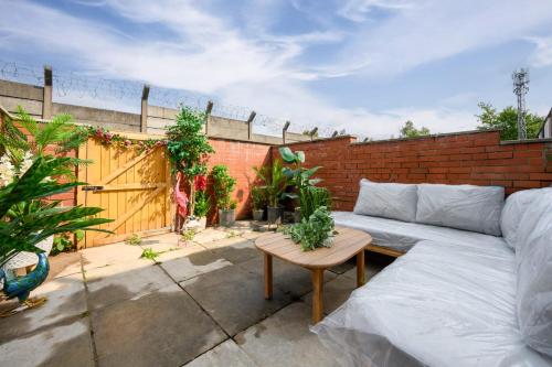 a patio with a couch and a table on a brick wall at SLUXE Properties 4mins to Etihad Stadium and Coop live in Manchester