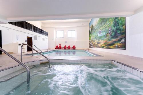a swimming pool in a building with a painting on the wall at Prestige Radium Hot Springs Resort, WorldHotels Crafted in Radium Hot Springs