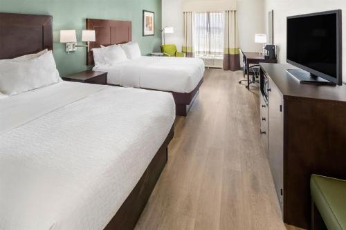 a hotel room with two beds and a flat screen tv at Best Western Plus Duncanville Dallas in Duncanville