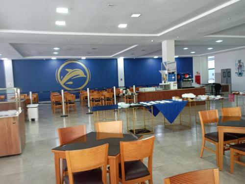 um restaurante com mesas e cadeiras e uma parede azul em Suíte Lari em Caldas Novas