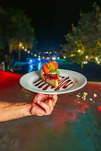 a hand holding a plate with a piece of food on it at Khaban Bacalar Hotel Boutique in Bacalar