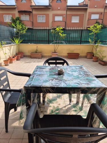 a glass table and chairs on a patio at Factory 219 Apartment Guidonia in Guidonia