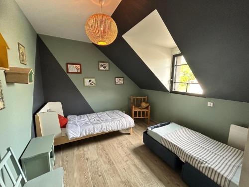 - une chambre avec 2 lits dans une chambre au plafond dans l'établissement Holiday Home in Normandy near Sandy Beach, à Saint Martin de Brehal