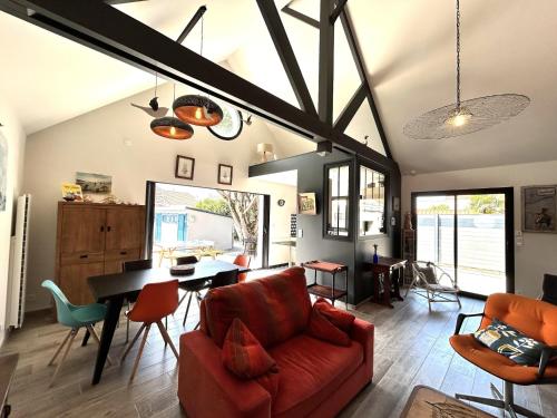 un salon avec un canapé rouge et une table dans l'établissement Holiday Home in Normandy near Sandy Beach, à Saint Martin de Brehal