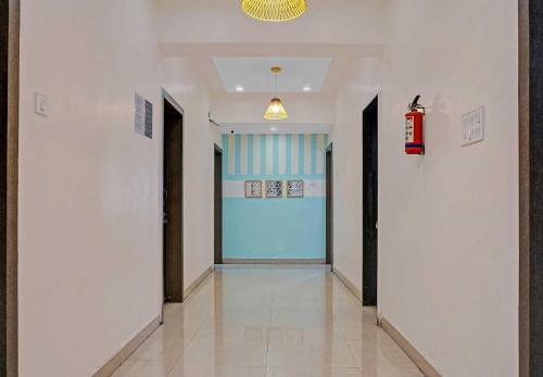 a hallway with a blue door in a building at Super Hotel O Pimpri Stays in Chinchiwad