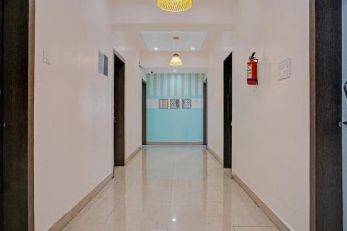 a hallway with white walls and a blue door at Super Hotel O Pimpri Stays in Chinchiwad