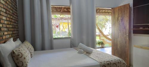 a bedroom with a bed and a window at Chalés da Cris in Fortim