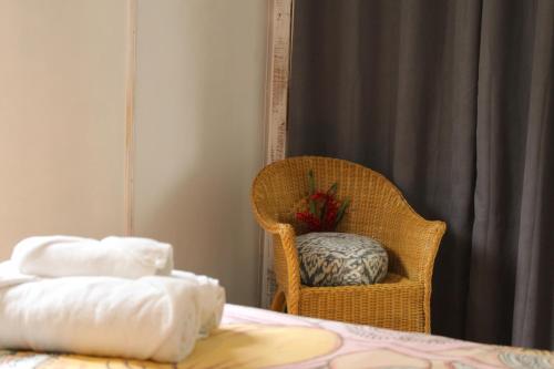 a room with a bed and a chair and a pillow at Olivia del caribe suite in Puerto Viejo