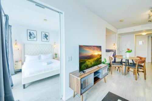 a bedroom with a bed and a table with a tv at RivetStays - The Jarvis in Toronto