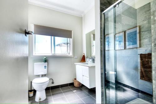 Un baño con inodoro y ducha de cristal. en Blue Haven Venus Bay, en Venus Bay