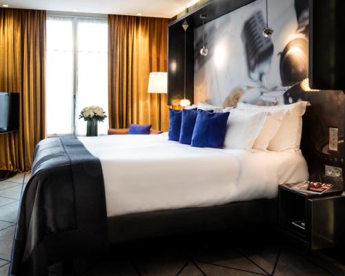 a hotel room with a bed and a lamp at Hôtel De Sers Champs Elysées Paris in Paris