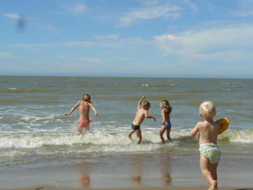 a group of children playing in the water at the beach at Studio in Wenduine near the Beach in Wenduine