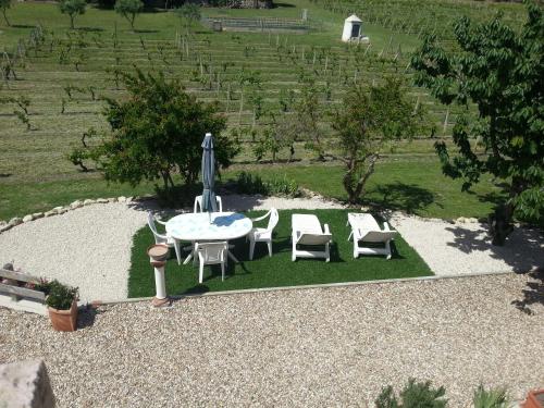 a patio with a table and chairs and an umbrella at SERRA E MESU Affittacamere in Magomadas
