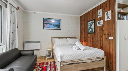 a bedroom with a bed and a couch at Alpine Haven 4 in Mount Hotham