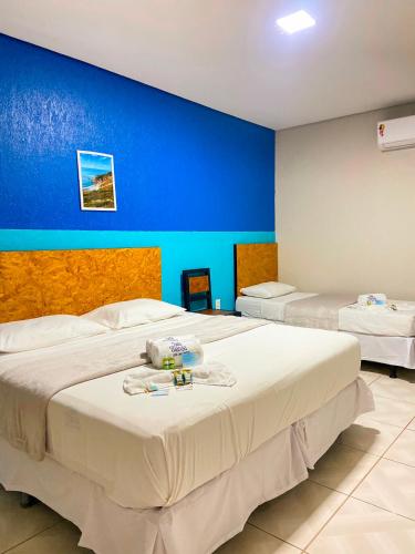 two beds in a room with a blue wall at Pousada Vila Mansa Jeri in Jericoacoara