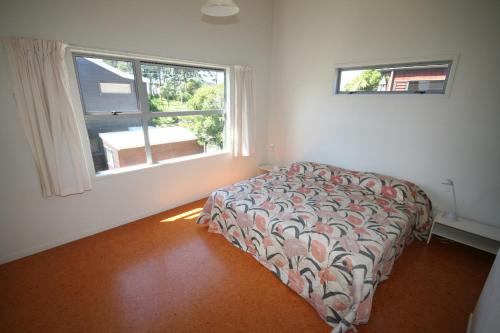a bedroom with a bed and a window at OCEA507B - SURF SEA SAND in Whangamata