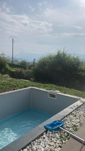 une piscine avec un kayak bleu posé dessus dans l'établissement La Villa du Silence Ouvrier, à Saint-Martin-d'Uriage