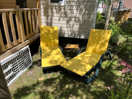 2 chaises jaunes assises sur une terrasse couverte dans l'établissement LES OYATS 4 ETOILES MOBIL HOME PRESTIGE 5 Personnes, à Seignosse