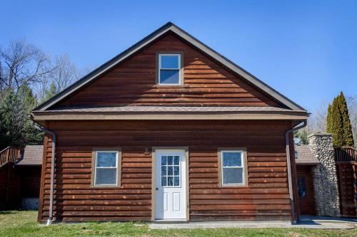 a wooden house with a white door and windows at Norris View in Dundee