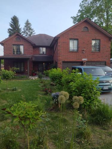 a brick house with a car parked in front of it at Luxury Suites at Military Trail in Toronto