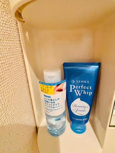 a box with a bottle of sunscreen and a container of water at まるまる貸切のアパートマンション名古屋駅エリアから1駅 in Nagoya