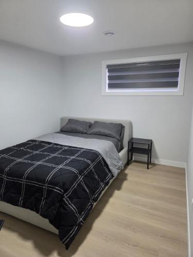 a white bedroom with a bed and a window at Exclusive Suite in Edmonton in Edmonton