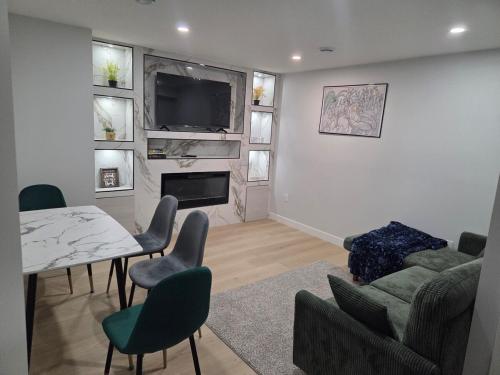 a living room with a table and chairs and a television at Exclusive Suite in Edmonton in Edmonton