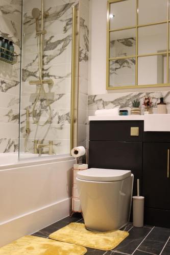 a bathroom with a toilet and a sink and a shower at Central Costal Getaway in Brighton & Hove