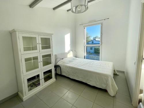une chambre blanche avec un lit et une fenêtre dans l'établissement Maison spacieuse 3 ch. avec jardin, proche du centre, parking, WIFI - FR-1-231-198, à Bretignolles-sur-Mer