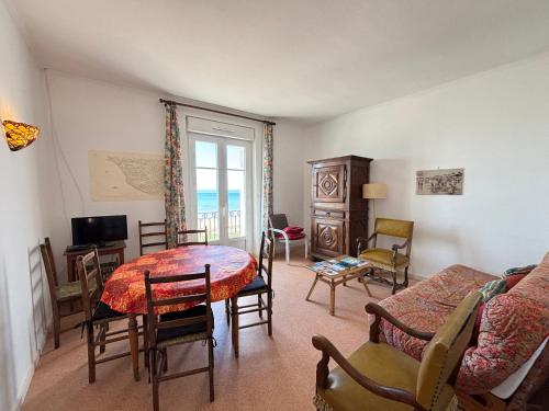 un salon avec une table et des chaises dans l'établissement Charmant appart centre-ville avec vue mer - FR-1-197-196, à Les Sables-dʼOlonne