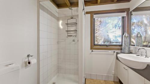 a white bathroom with a sink and a shower at Westons in Dinner Plain