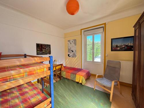 une chambre avec un lit superposé et une chaise dans l'établissement Appartement T4 face mer, proche commerces, 2 balcons, cuisine équipée, 2ème étage sans ascenseur - FR-1-197-271, à Les Sables-dʼOlonne