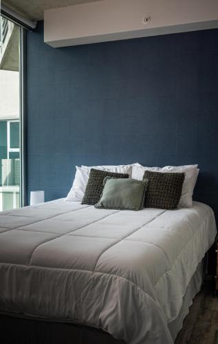 a bedroom with a large bed with a blue wall at Man Cave in San José