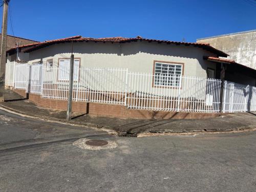 a white fence in front of a house at Casa Aconchegante Alfenas in Alfenas