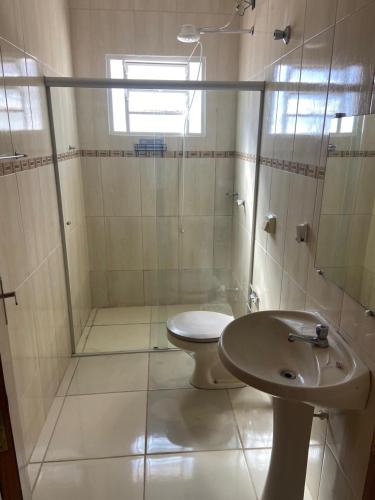 a bathroom with a toilet and a shower and a sink at Casa Aconchegante Alfenas in Alfenas